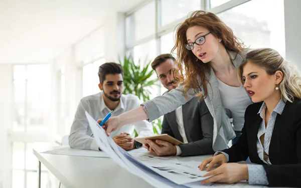 four people looking over paperwork